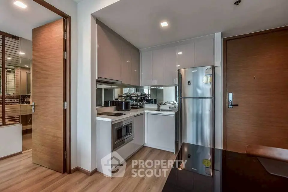 Modern kitchen with sleek cabinetry and stainless steel appliances in a stylish apartment.
