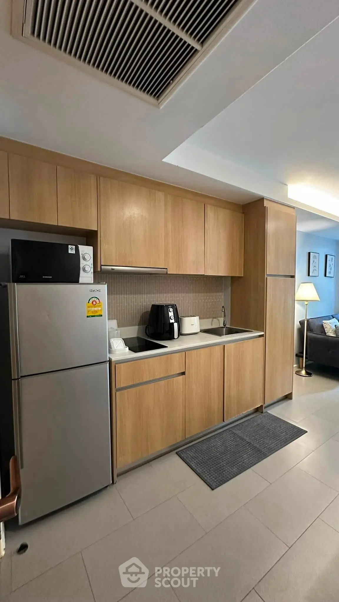 Modern kitchen with sleek wooden cabinets and stainless steel appliances in a stylish apartment.