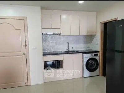 Modern compact kitchen with integrated appliances and sleek cabinetry