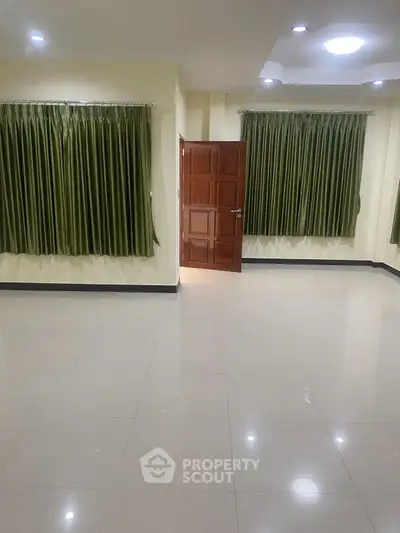 Spacious empty room with tiled floor and green curtains, perfect for customization.