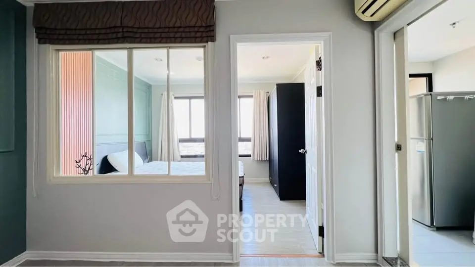 Modern apartment interior with bedroom and kitchen, featuring large windows and sleek design.