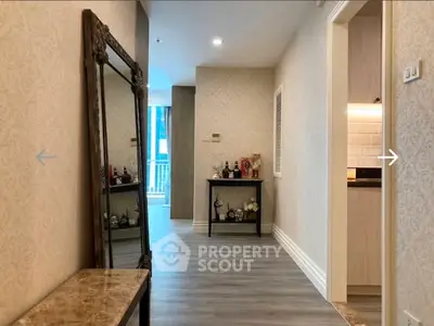 Elegant hallway with decorative mirror and modern kitchen view, perfect for stylish living.