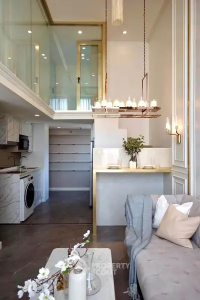 Luxurious modern living room with mezzanine, elegant chandelier, and stylish open kitchen design.