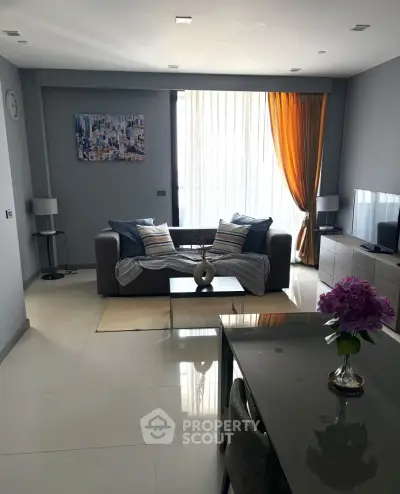 Modern living room with sleek furniture and large window, offering a cozy and stylish ambiance.