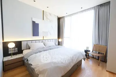Elegant bedroom with modern decor, large window, and stylish furniture, perfect for relaxation and comfort.