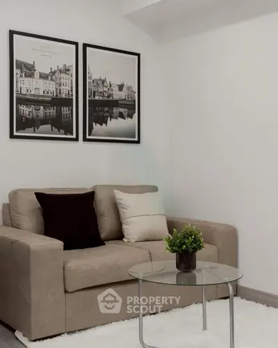 Cozy living room with stylish sofa, glass coffee table, and elegant wall art.