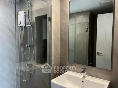 Modern bathroom with sleek shower and elegant sink in contemporary design.