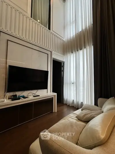 Luxurious high-ceiling living room with elegant decor and large windows