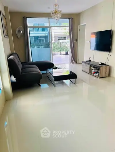 Spacious modern living room with sleek furniture and large windows offering natural light.
