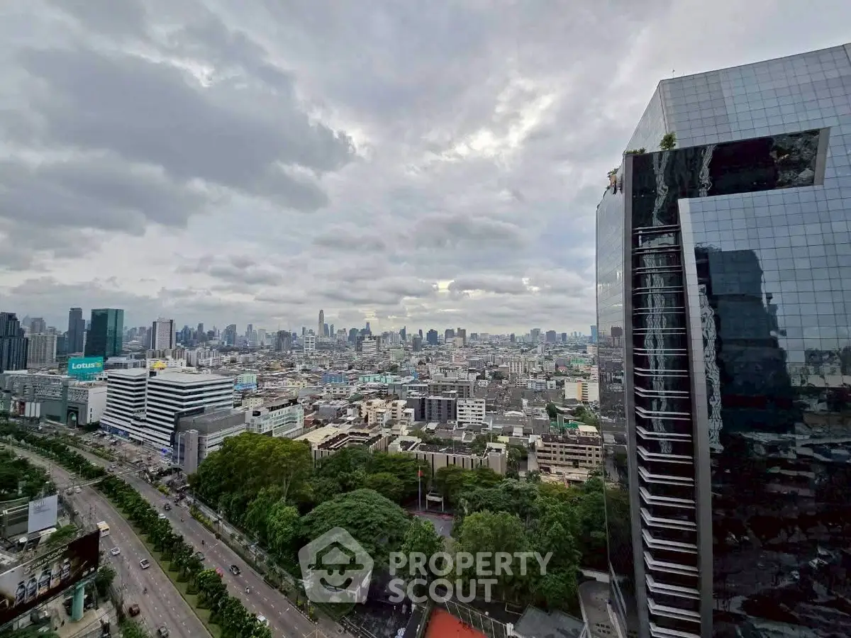 Stunning cityscape view from a high-rise building with lush greenery and urban skyline.
