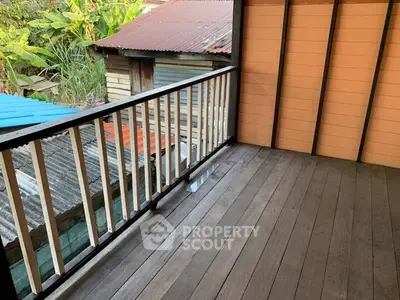 Charming rustic balcony with wooden flooring and scenic view of neighboring rooftops.