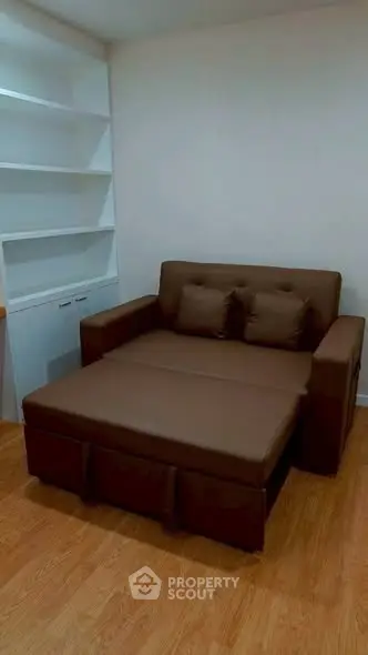 Cozy living room with brown sofa and built-in white shelves