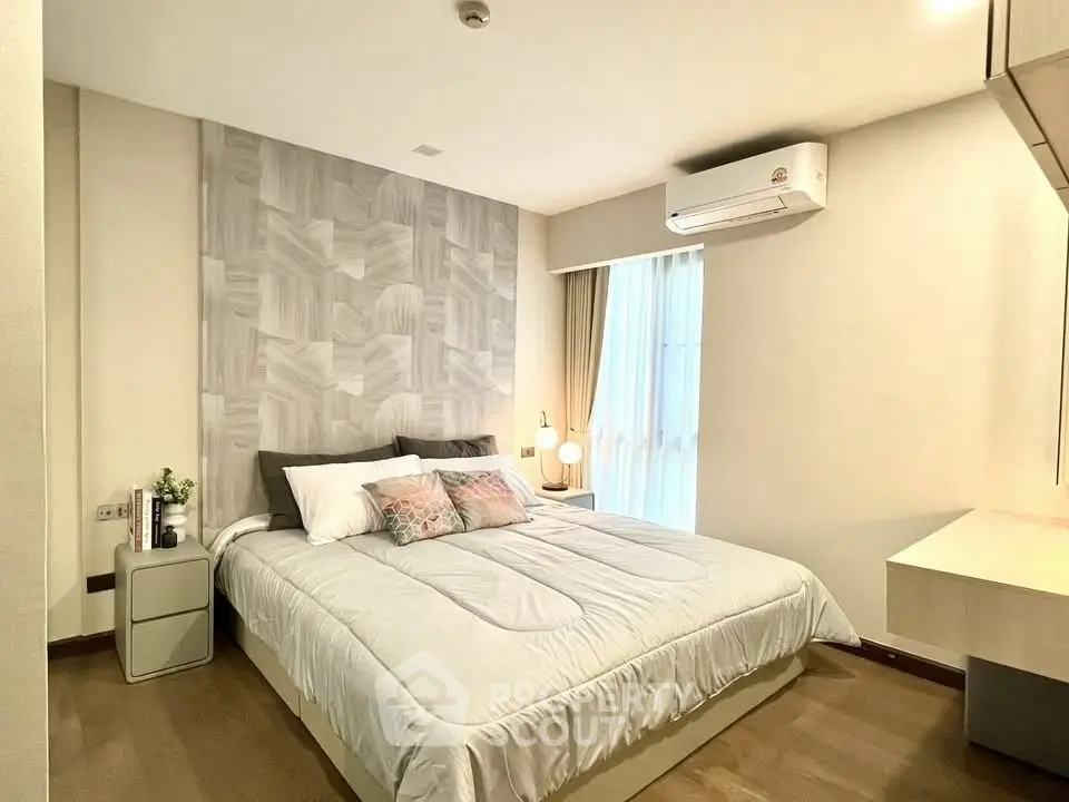 Modern bedroom with stylish decor and natural light, featuring a comfortable bed and elegant furnishings.