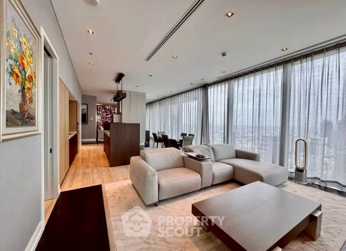 Spacious modern living room with panoramic city views and elegant decor.