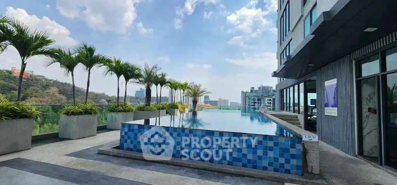 Stunning rooftop infinity pool with city skyline views and lush greenery.