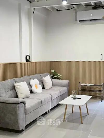 Modern living room with stylish gray sofa and minimalist decor