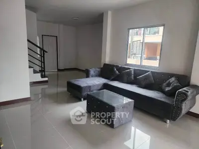 Spacious living room with modern gray sectional sofa and glass coffee table