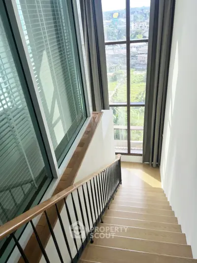 Elegant staircase with large window offering stunning city view in modern home