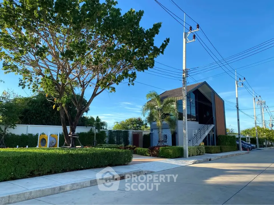 Modern residential building with lush greenery and clear blue sky