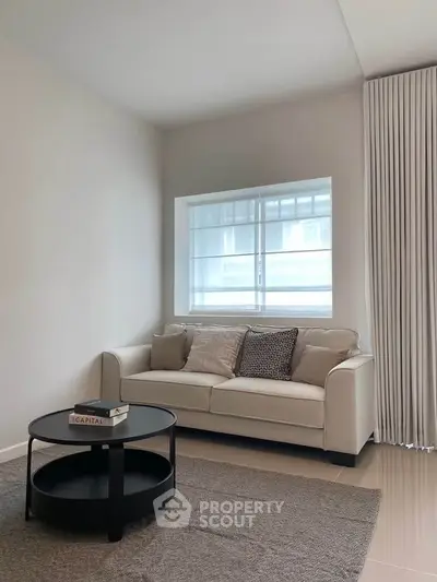 Modern living room with cozy sofa and stylish coffee table in bright natural light.