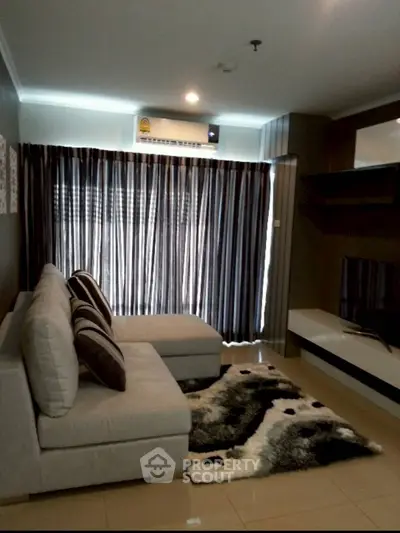 Modern living room with cozy sofa, stylish rug, and air conditioning in a chic apartment.
