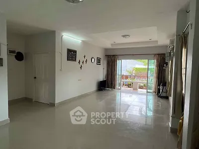 Spacious living room with large windows and garden view, perfect for family gatherings.