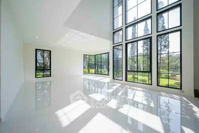 Spacious modern living room with large windows and garden view, flooded with natural light.