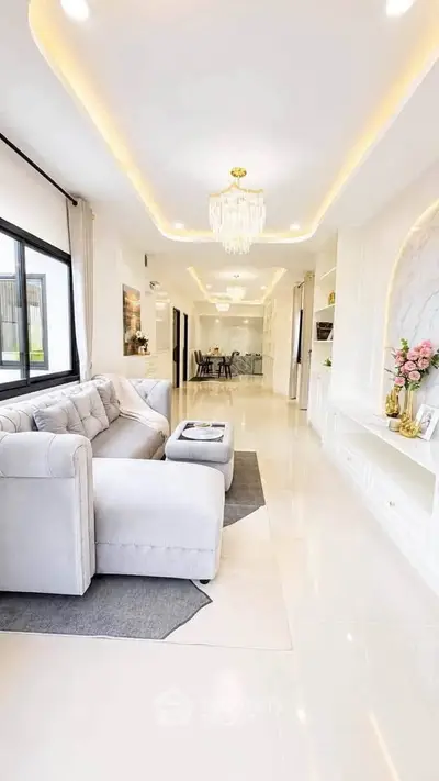 Luxurious open-plan living room with elegant chandelier and modern decor, perfect for stylish entertaining.