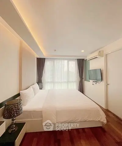 Spacious bedroom with modern decor and natural light in a stylish apartment.