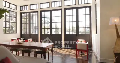 Spacious living room with large windows and elegant dining area