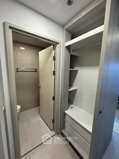 Modern bathroom entrance with sleek storage unit and neutral tones