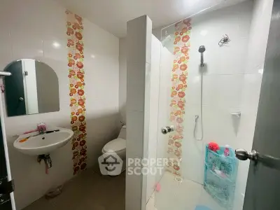 Charming bathroom with floral tile accents and modern shower design.