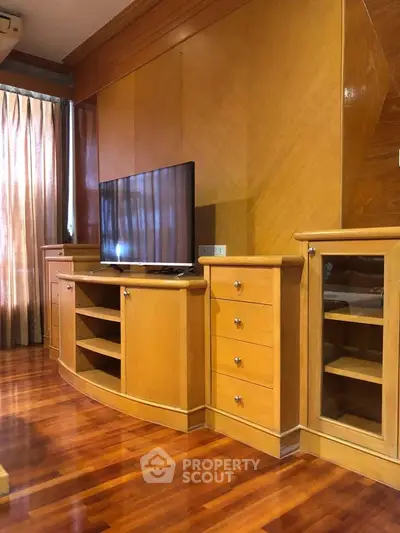 Elegant living room with polished wooden floors and built-in TV cabinet
