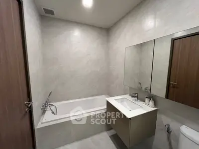 Modern bathroom with bathtub and sleek vanity in minimalist design.