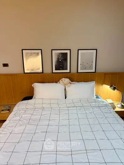 Cozy bedroom with modern decor and stylish artwork above the bed, perfect for relaxation.