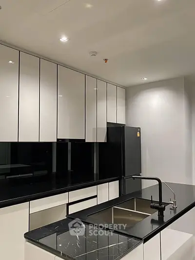 Modern kitchen with sleek black countertops and high-gloss cabinets