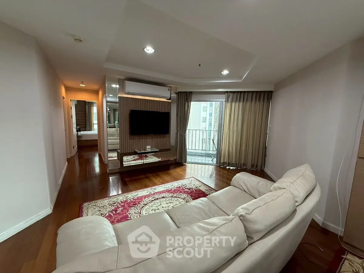 Spacious living room with elegant decor and balcony access in modern apartment.
