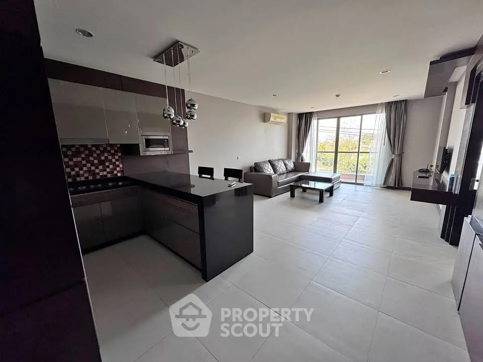 Modern open-layout living room with sleek kitchen and stylish decor