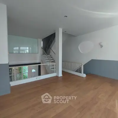 Spacious modern interior with wooden flooring and stylish staircase