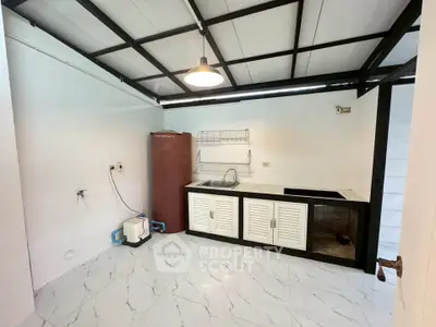 Modern kitchen with sleek design and open layout, featuring a water heater and stylish lighting.