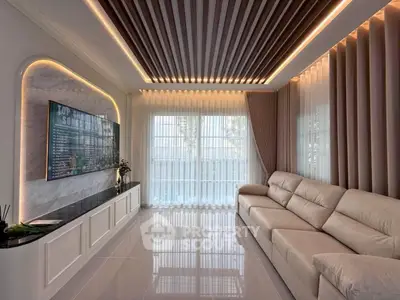 Luxurious living room with modern design, featuring a plush sofa and elegant ceiling lighting.