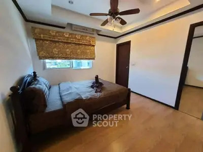 Spacious bedroom with elegant ceiling fan and wooden flooring