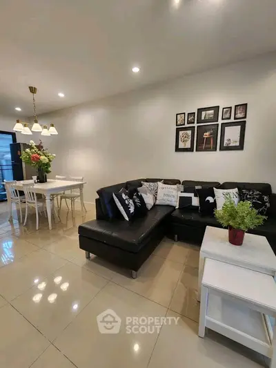 Modern living room with stylish black leather sofa and elegant dining area