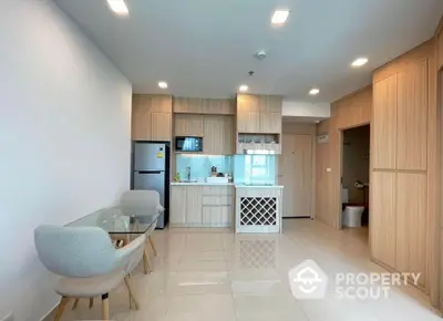 Modern kitchen with sleek cabinetry and dining area in open layout apartment