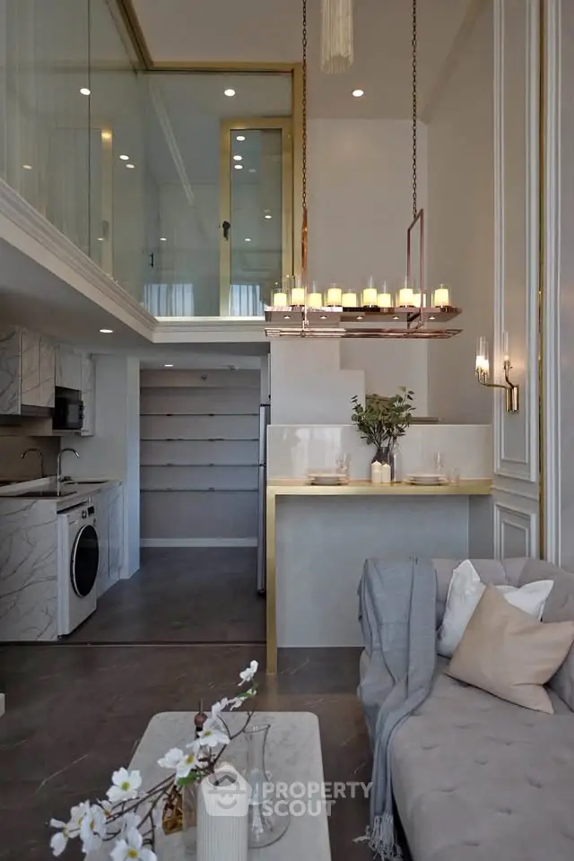 Luxurious modern living room with mezzanine, elegant chandelier, and stylish open kitchen in a sophisticated apartment.