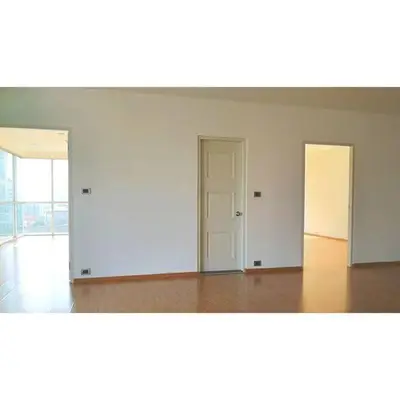 Spacious modern apartment interior with wooden flooring and bright natural light.