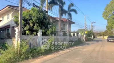 Charming suburban house with lush greenery and palm trees, perfect for serene living.