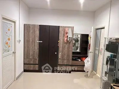 Spacious bedroom with modern wardrobe and tiled flooring
