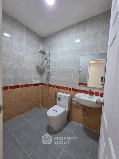 Modern bathroom with tiled walls, shower, and sleek fixtures in a contemporary home.