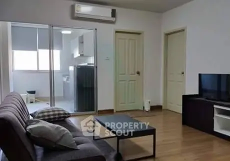 Modern living room with sleek furniture and open kitchen layout in a stylish apartment.